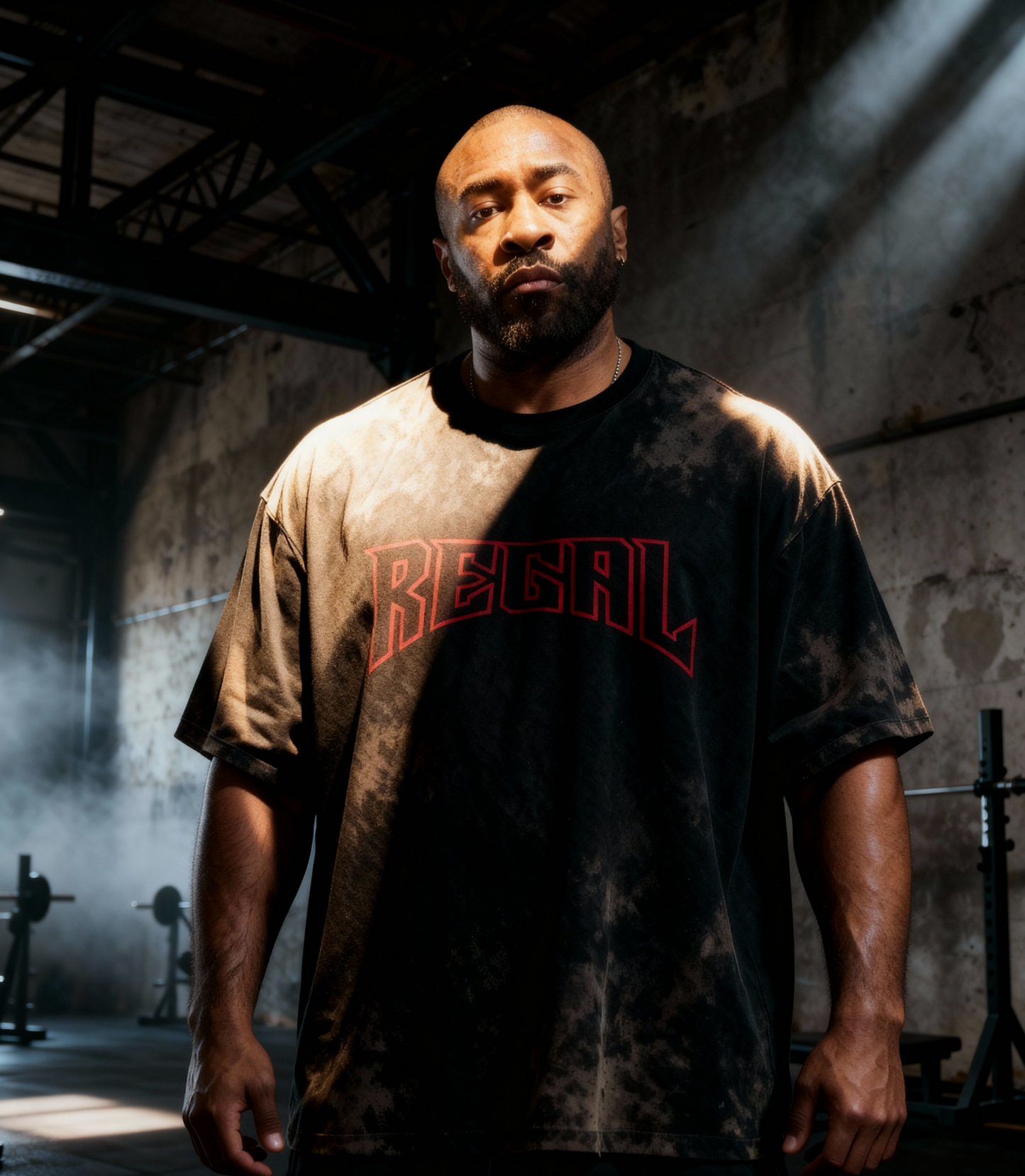 Man wearing a 'Regal' t-shirt in a dimly lit industrial setting