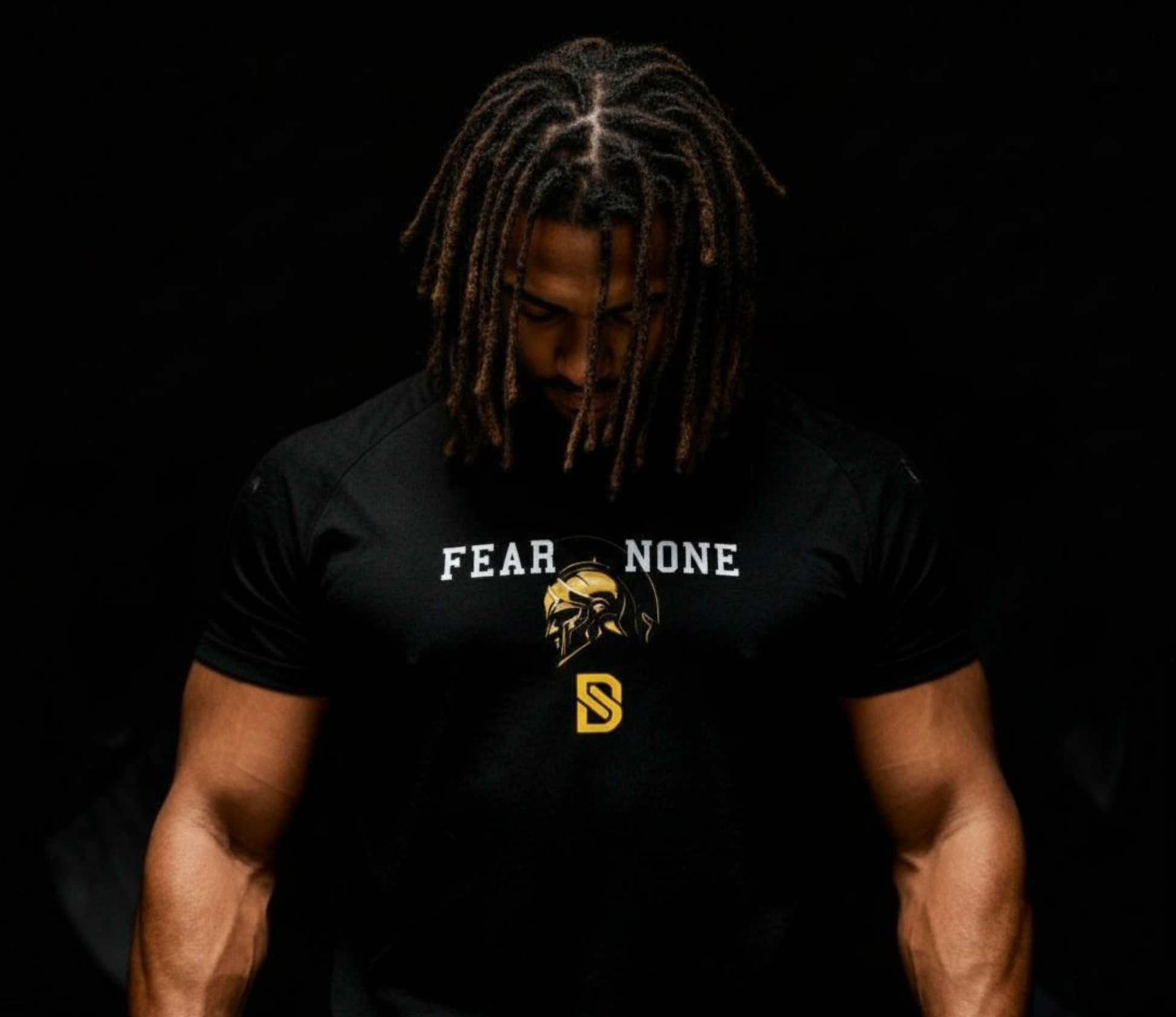 Person wearing a black t-shirt with 'FEAR NONE' text and logo on a dark background