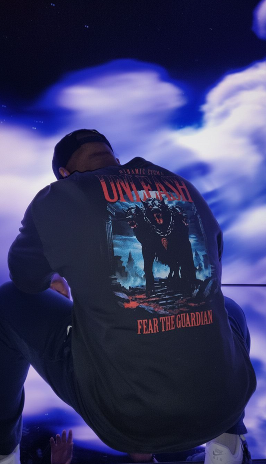 Person wearing a black hoodie with graphic design and text, standing against a dark background.
