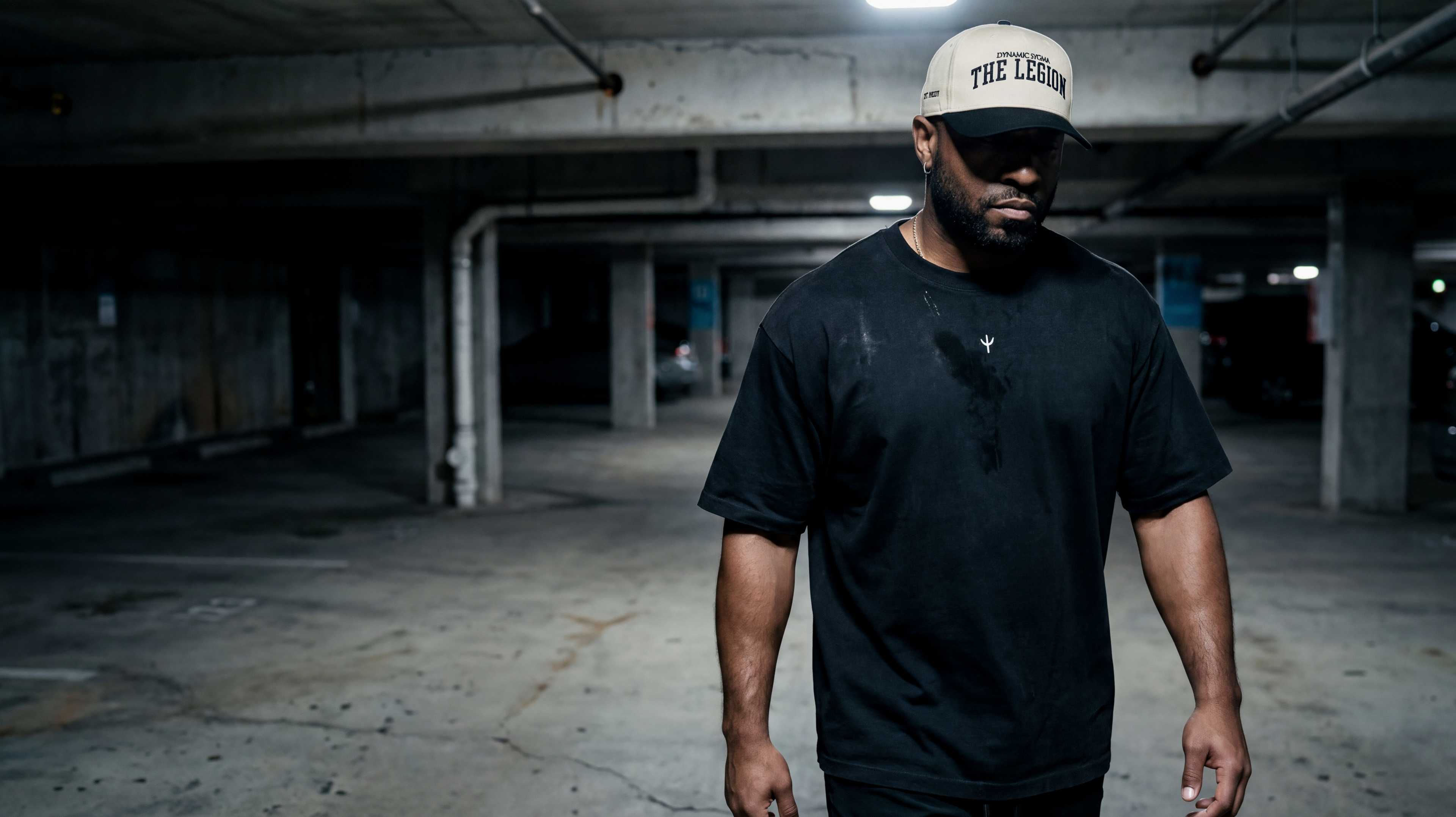 Man wearing the black Dynamic Sygma uniform in a concrete parking structure.